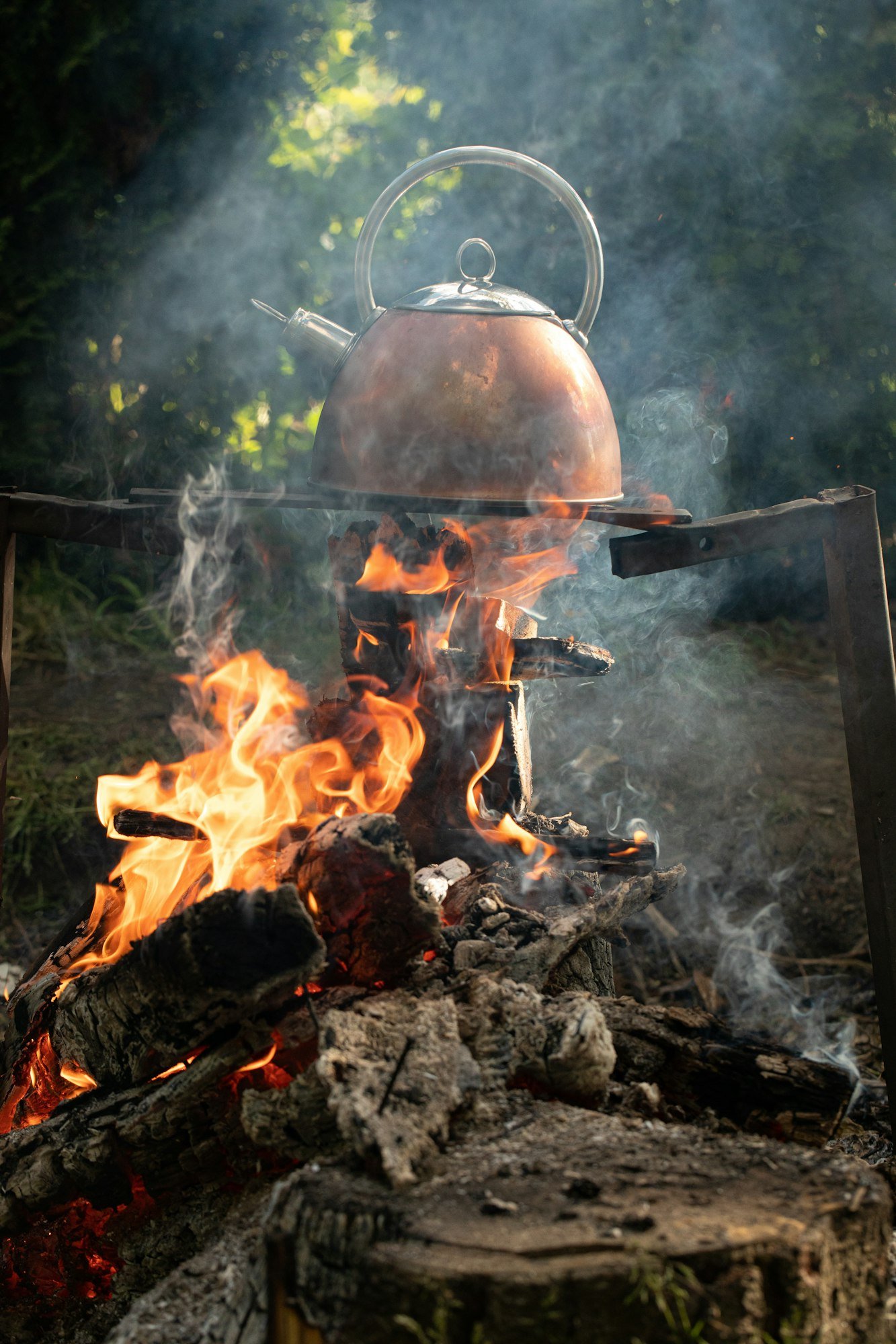 Warm water in a kettle on a campfire in nature.